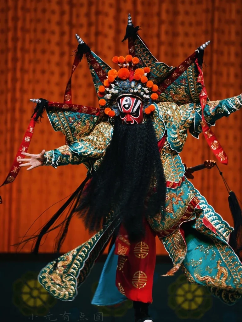Traditional Chinese Peking Opera performer in ornate costume and dramatic facial makeup on stage