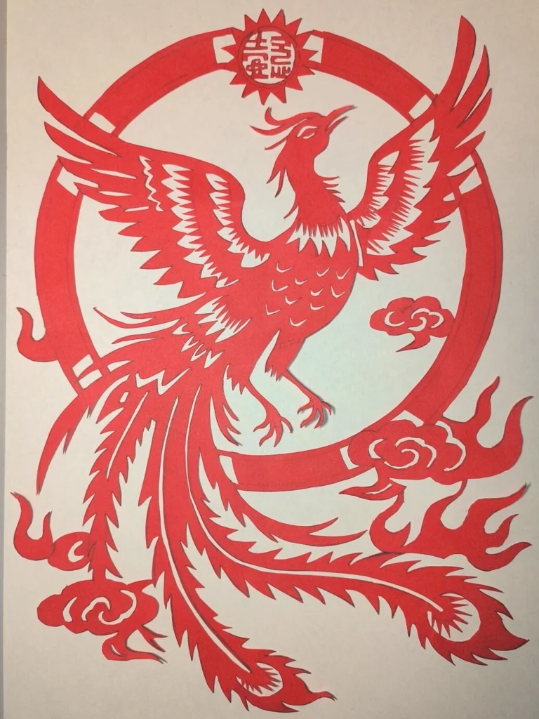 Traditional Chinese paper cutting art featuring a red phoenix circular folk decorative design